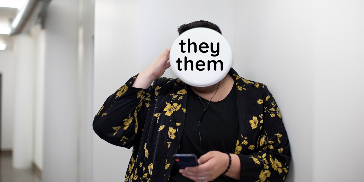 A person (https://unsplash.com/photos/xX7sYu7iRZk) with a pronoun pin (https://unsplash.com/photos/NxB2c2hakYI) instead of their head